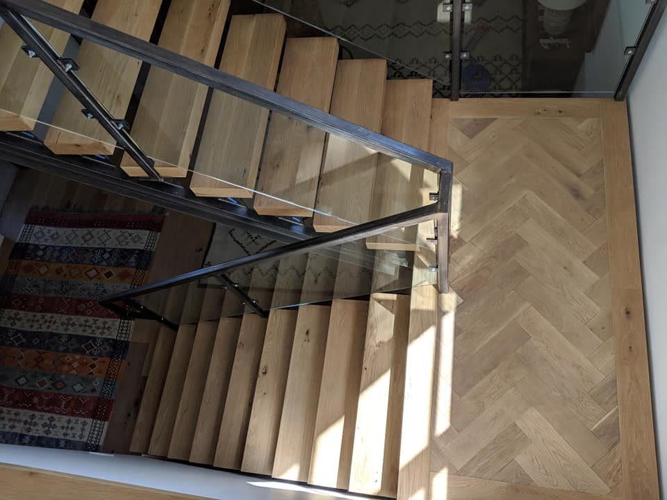 aerial view of a wooden stair case with black wood railings